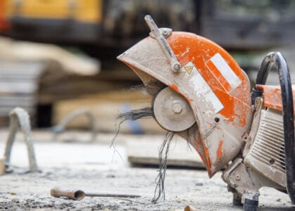 Bright orange petrol saw with a broken carbon fibre blade